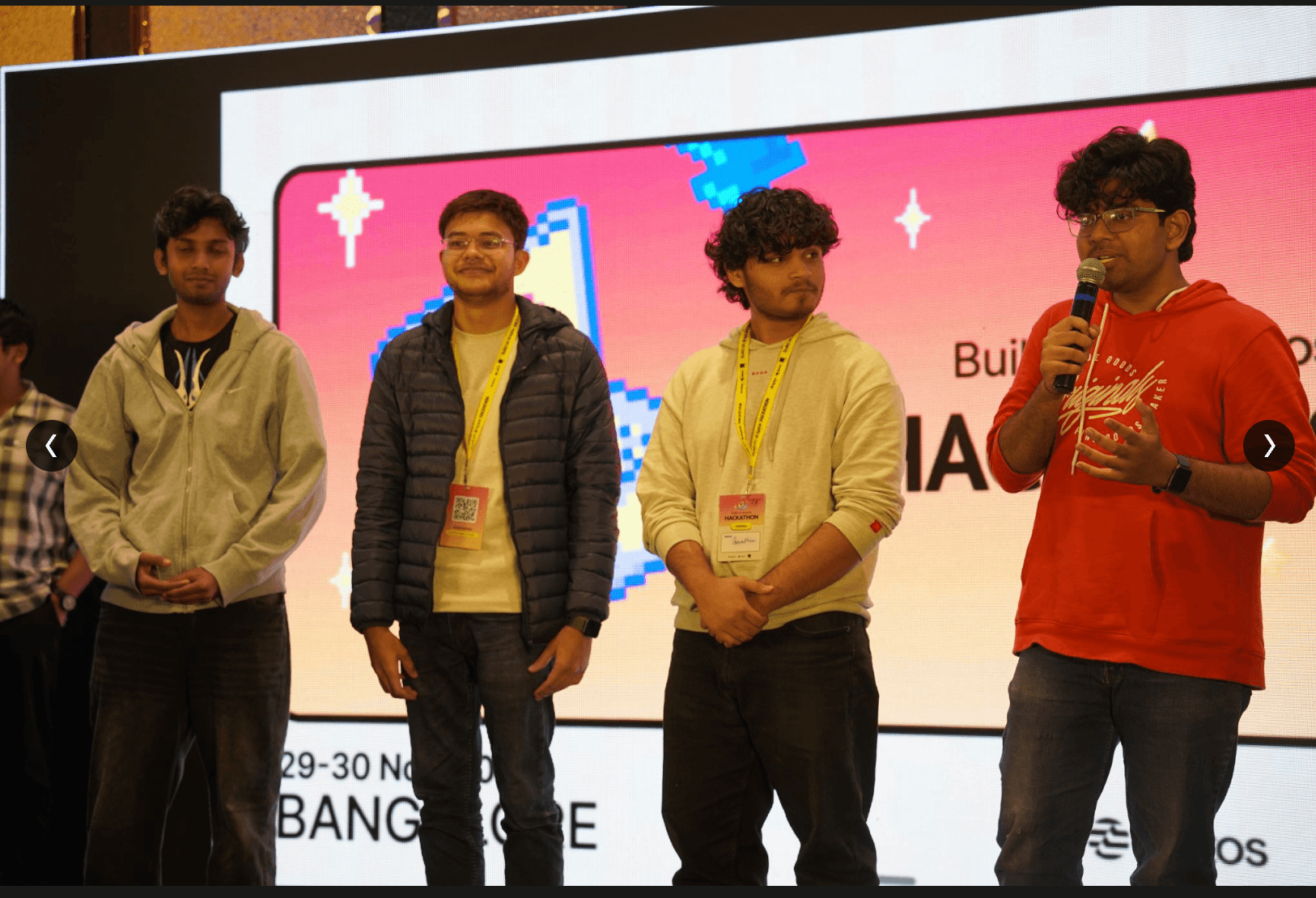 Team presenting on stage at the Aptos Build Hackathon in Bangalore.